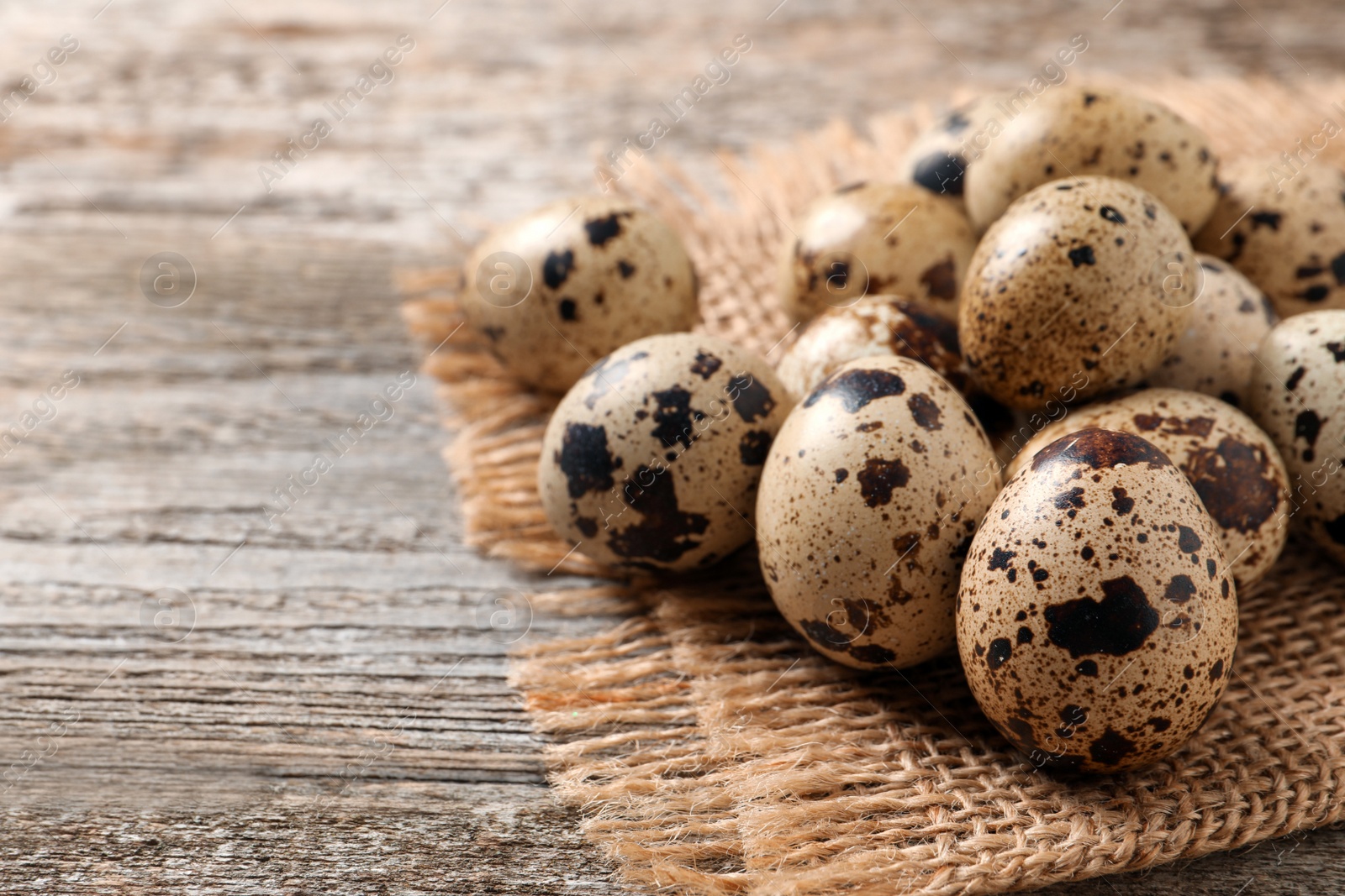 Photo of Fresh quail eggs on wooden table. Space for text