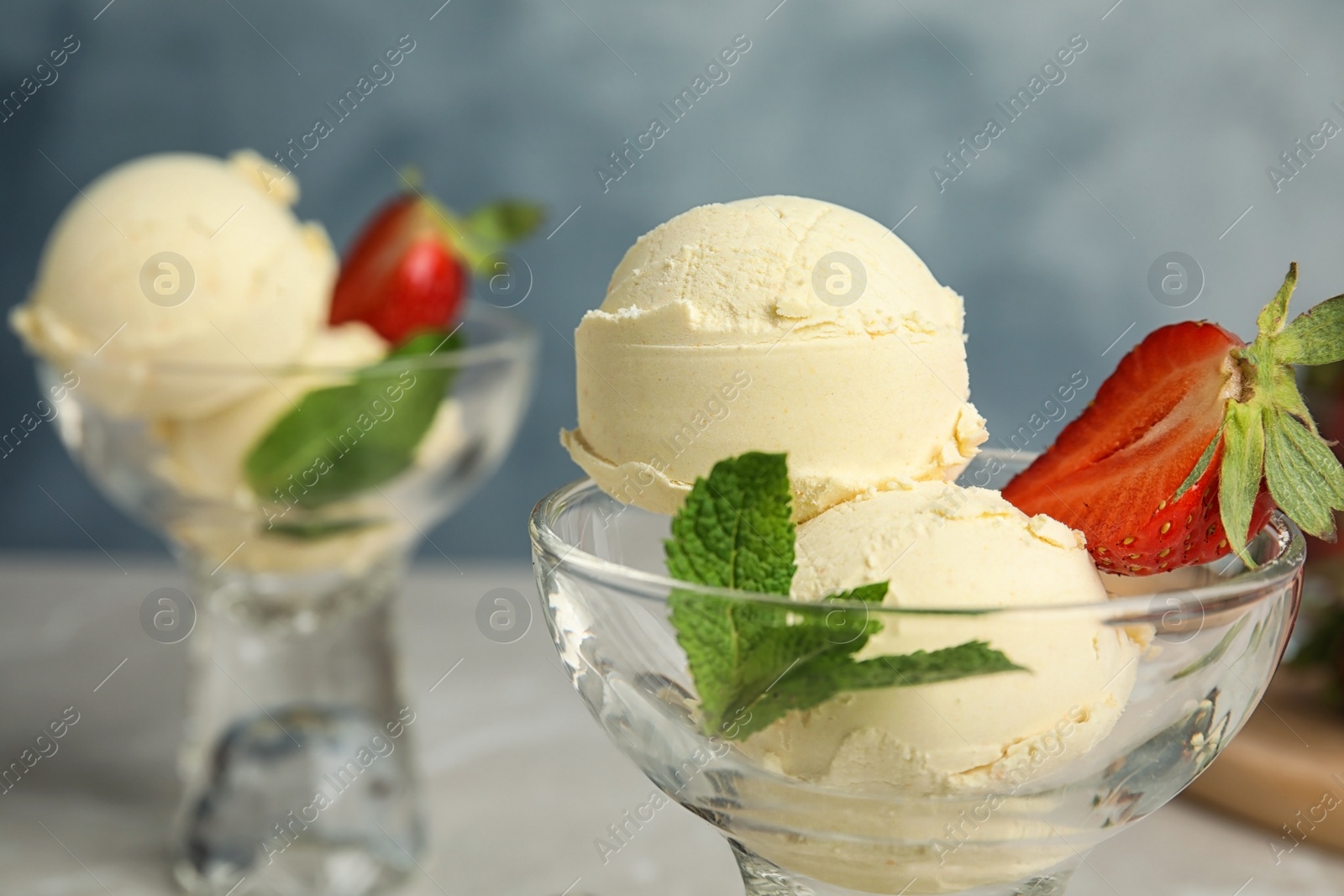 Photo of Delicious vanilla ice cream with strawberry served on table, closeup