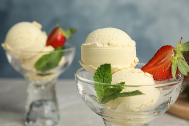 Delicious vanilla ice cream with strawberry served on table, closeup