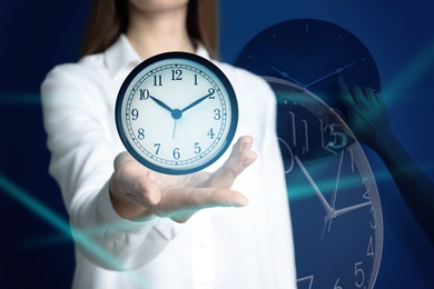Image of Time management concept. Woman with clock, closeup