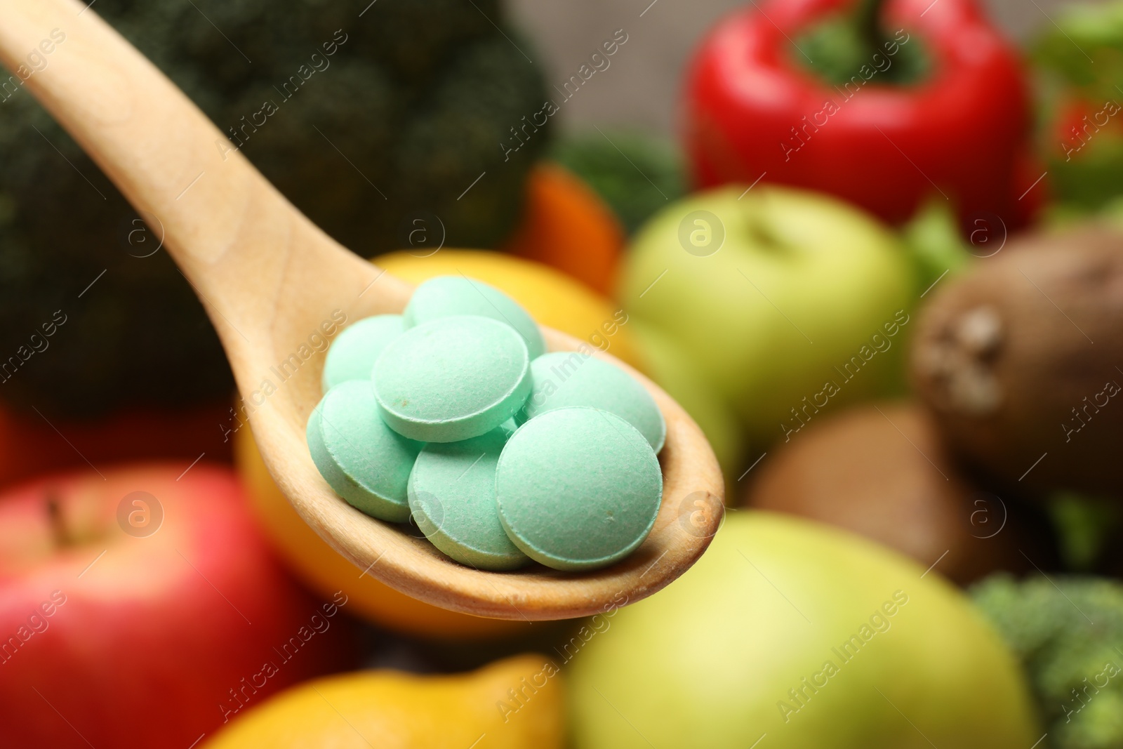 Photo of Dietary supplements. Spoon with pills over food products, closeup. Space for text