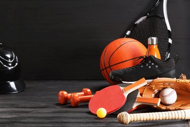 Photo of Many different sports equipment on dark grey wooden table