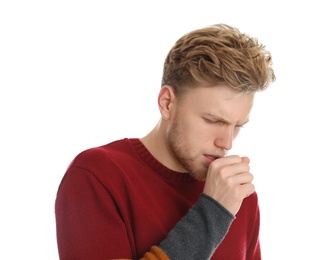 Handsome young man coughing against white background