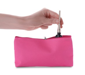 Photo of Woman taking eyeliner from pink cosmetic bag on white background, closeup