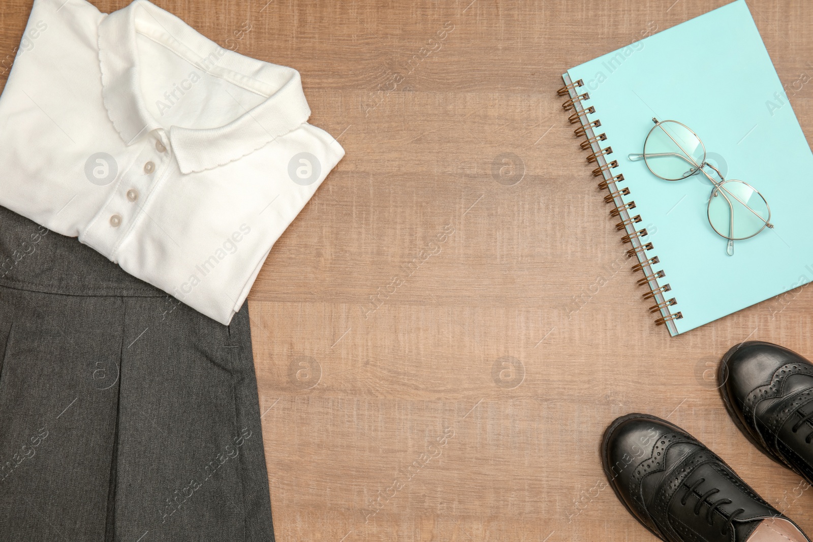 Photo of School uniform for girl on wooden background, top view