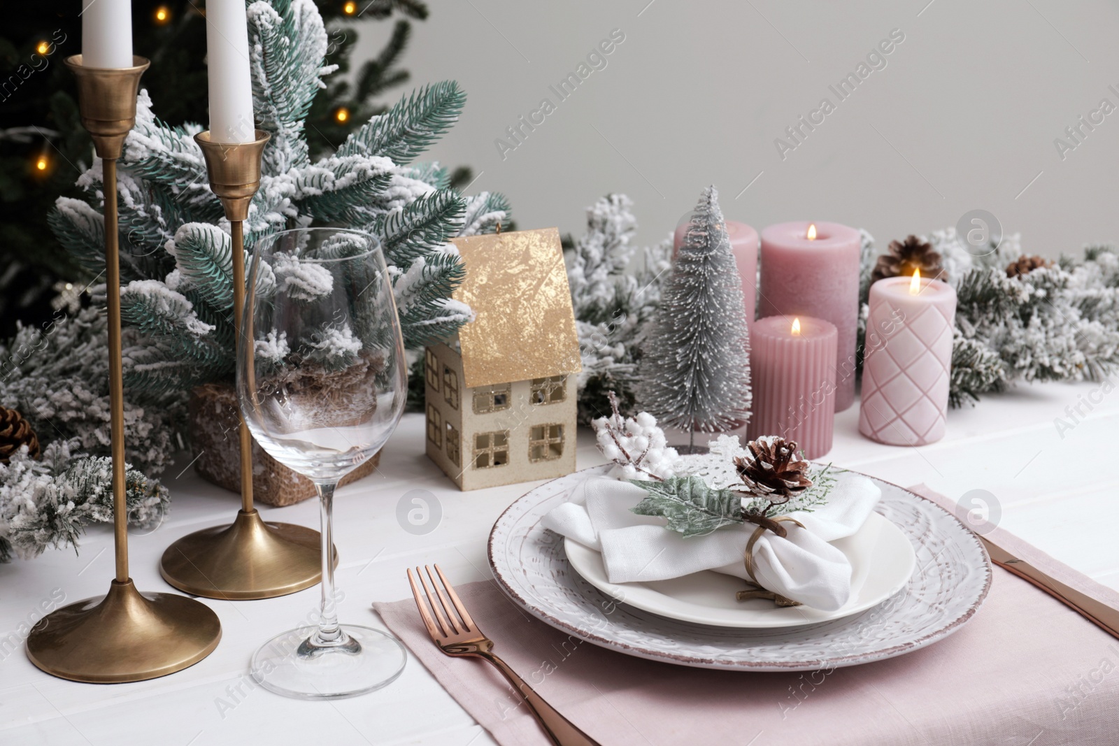 Photo of Festive place setting with beautiful dishware, cutlery and cone for Christmas dinner on white wooden table