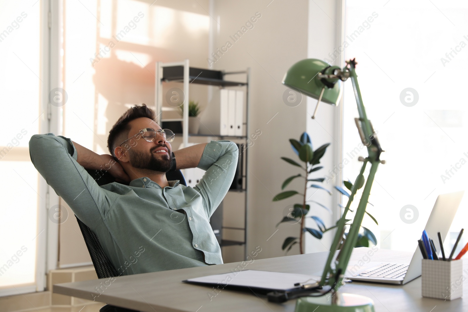 Photo of Businessman relaxing in office chair at workplace