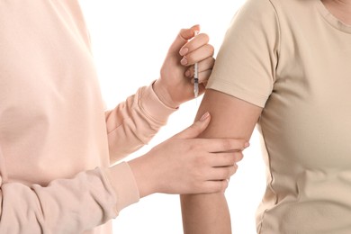 Photo of Diabetes. Woman getting insulin injection on white background, closeup