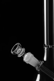 Photo of Closeup view of glass bong on black background. Smoking device