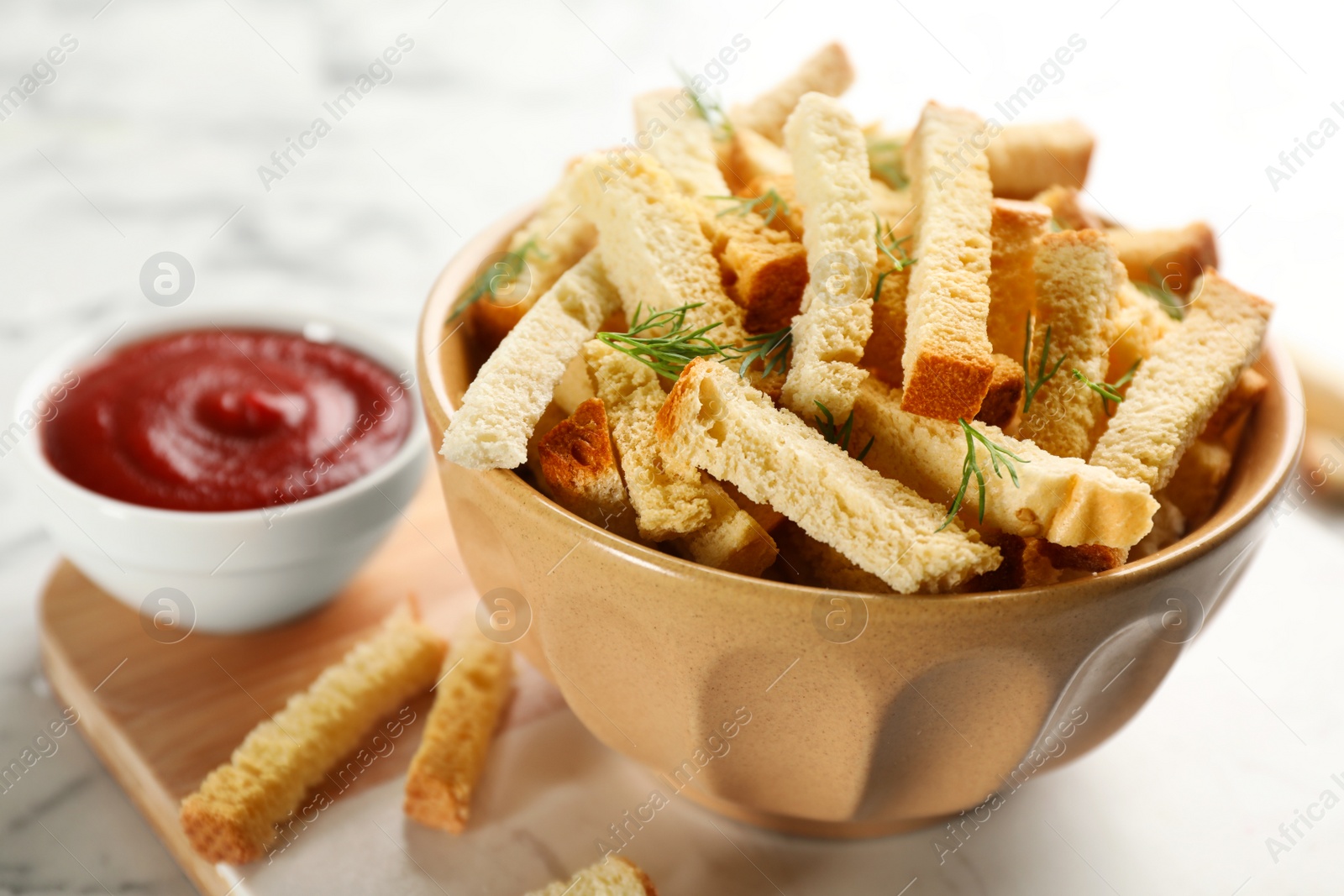 Photo of Delicious hard chucks with ketchup on wooden board, closeup