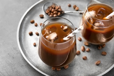 Glasses with cold brew coffee and beans on tray