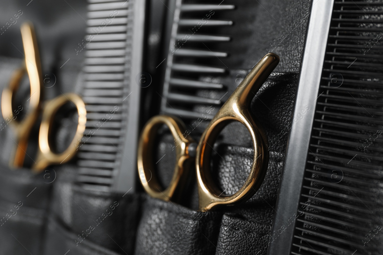 Photo of Hairdresser tools. Professional scissors and combs in leather organizer, closeup