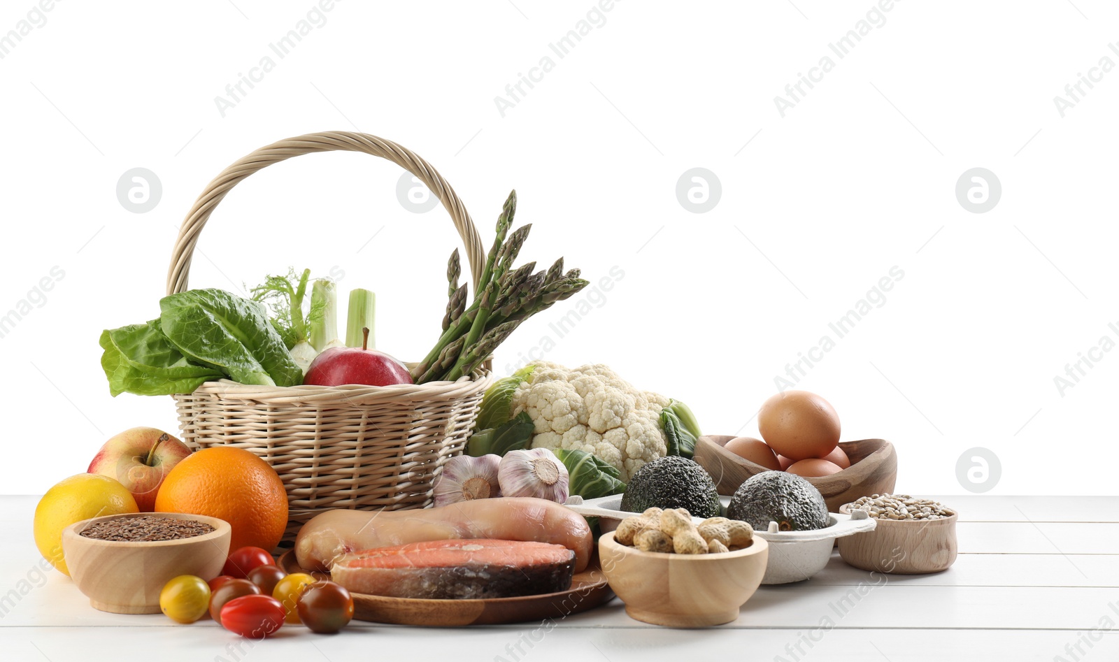 Photo of Healthy food. Basket with different fresh products on wooden table against white background