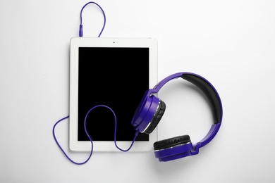 Photo of Stylish headphones and modern tablet on white background, top view