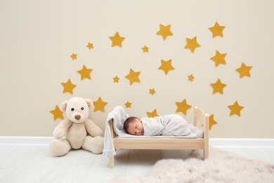 Adorable newborn baby sleeping in small bed