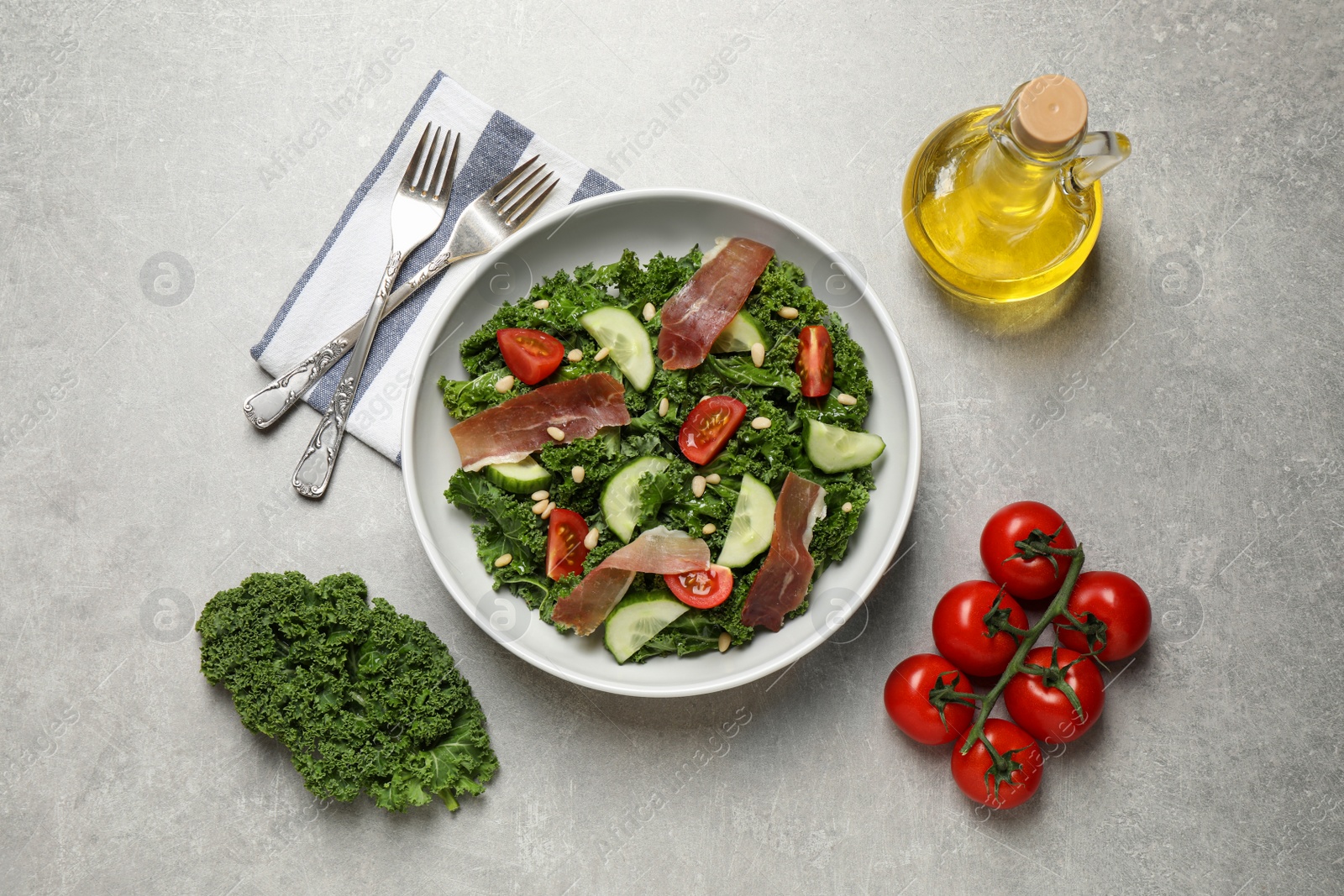 Photo of Delicious kale salad on light grey table, flat lay