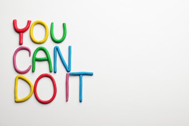 Photo of Motivational phrase You Can Do IT made of colorful plasticine on white background, flat lay. Space for text