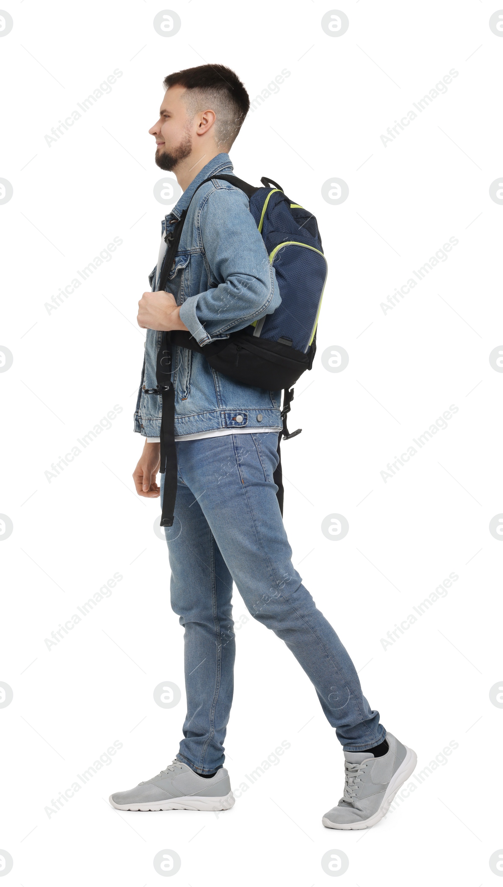 Photo of Man with backpack in denim clothes walking on white background