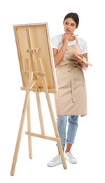 Photo of Young woman drawing on easel against white background