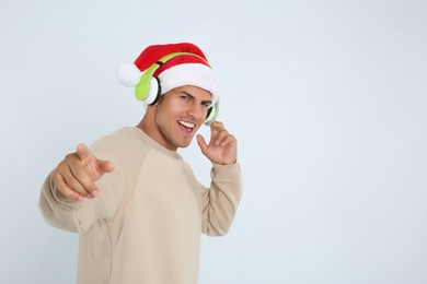 Photo of Emotional man with headphones on white background, space for text. Christmas music