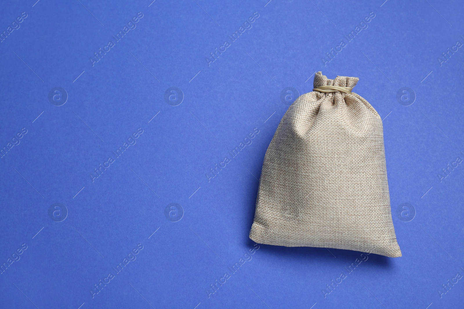 Photo of Burlap bag on blue background, top view. Space for text