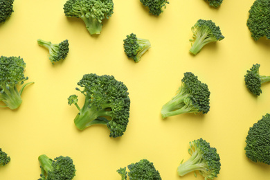 Photo of Fresh tasty broccoli on yellow background, flat lay