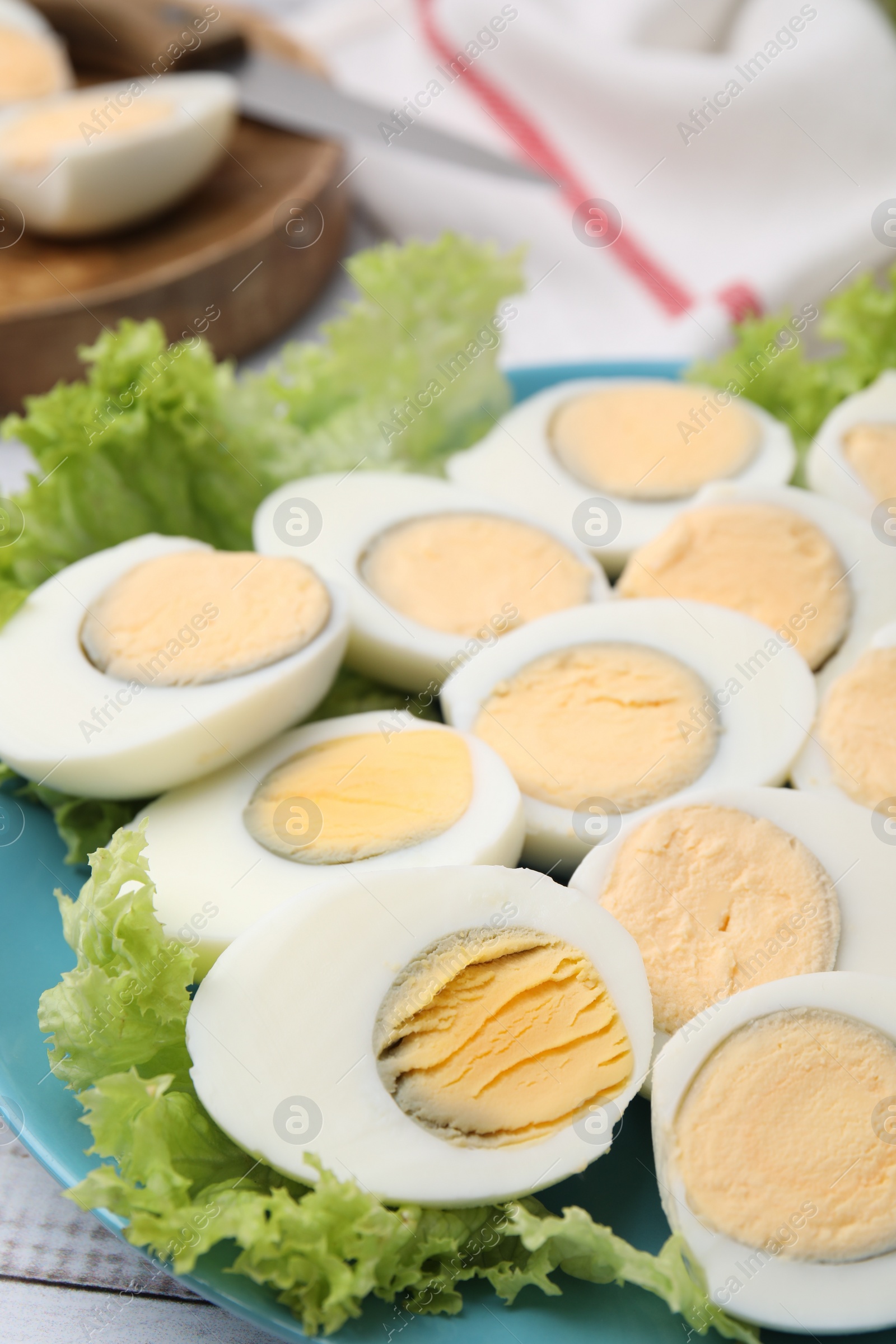 Photo of Fresh hard boiled eggs and lettuce on white wooden table