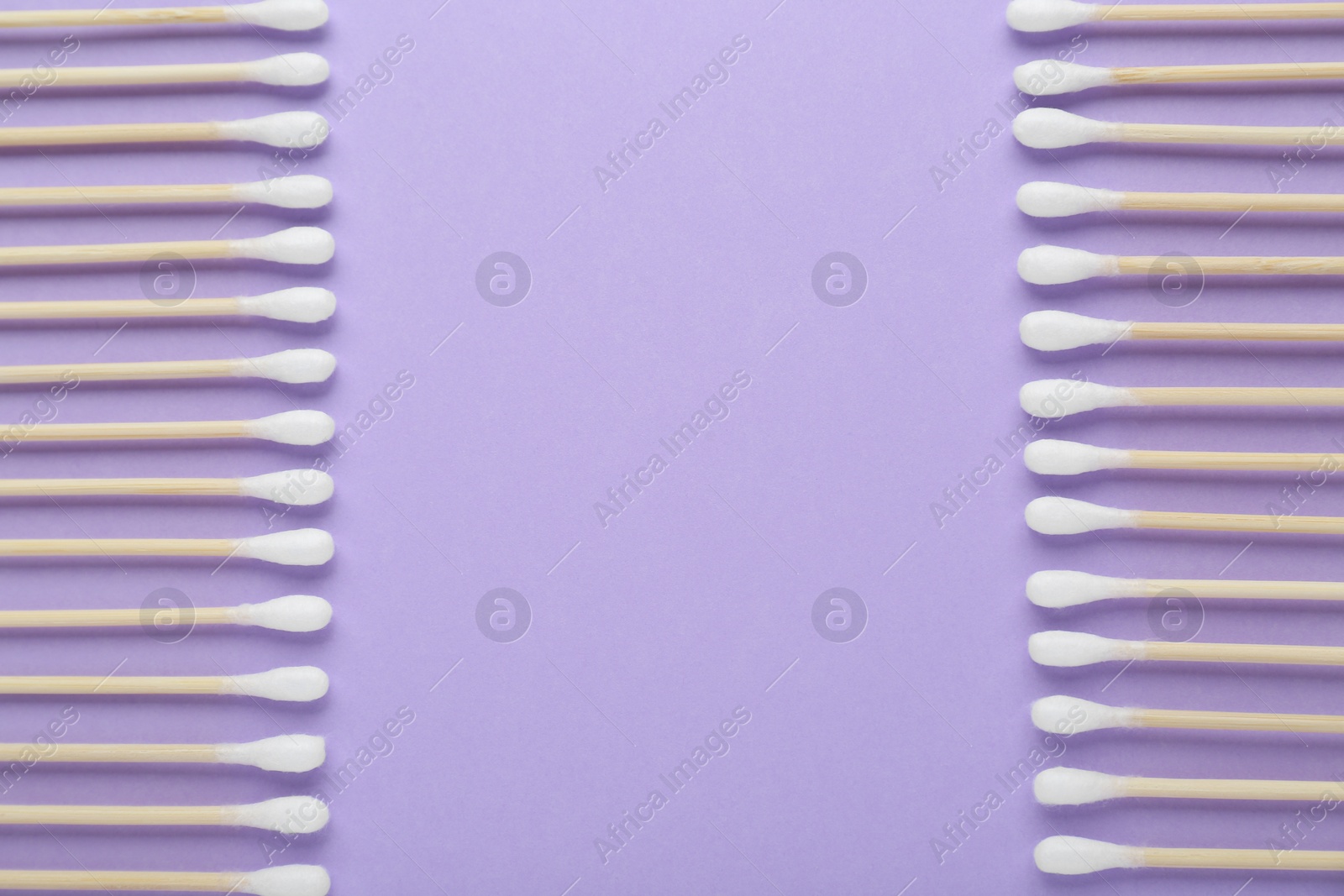 Photo of Many wooden cotton buds on violet background, flat lay. Space for text