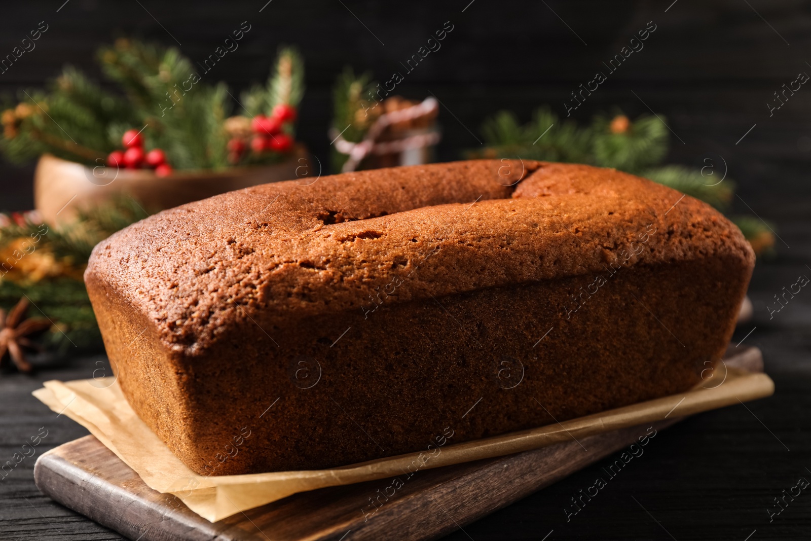 Photo of Delicious gingerbread cake on black wooden table, closeup