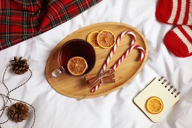 Photo of Flat lay composition with cup of hot winter drink on light fabric