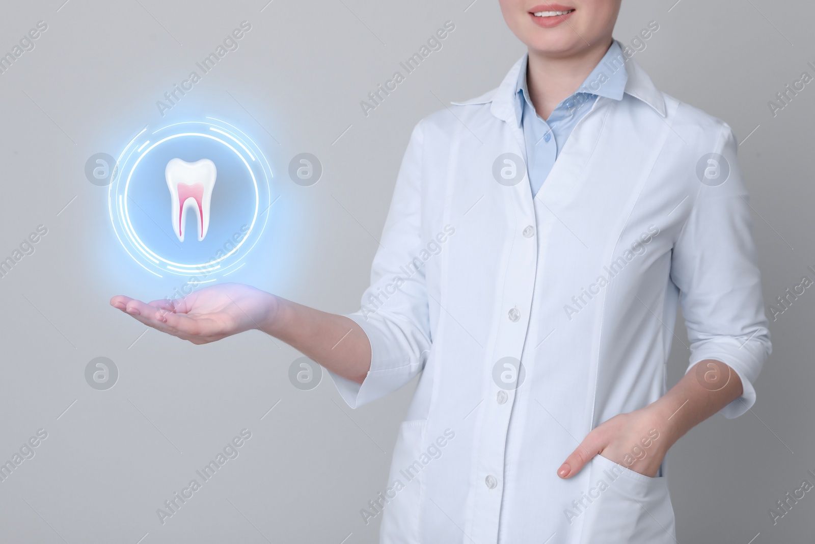 Image of Dentist showing virtual model of tooth on light grey background, closeup