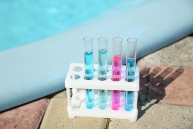 Test tubes with reagents in rack near swimming pool