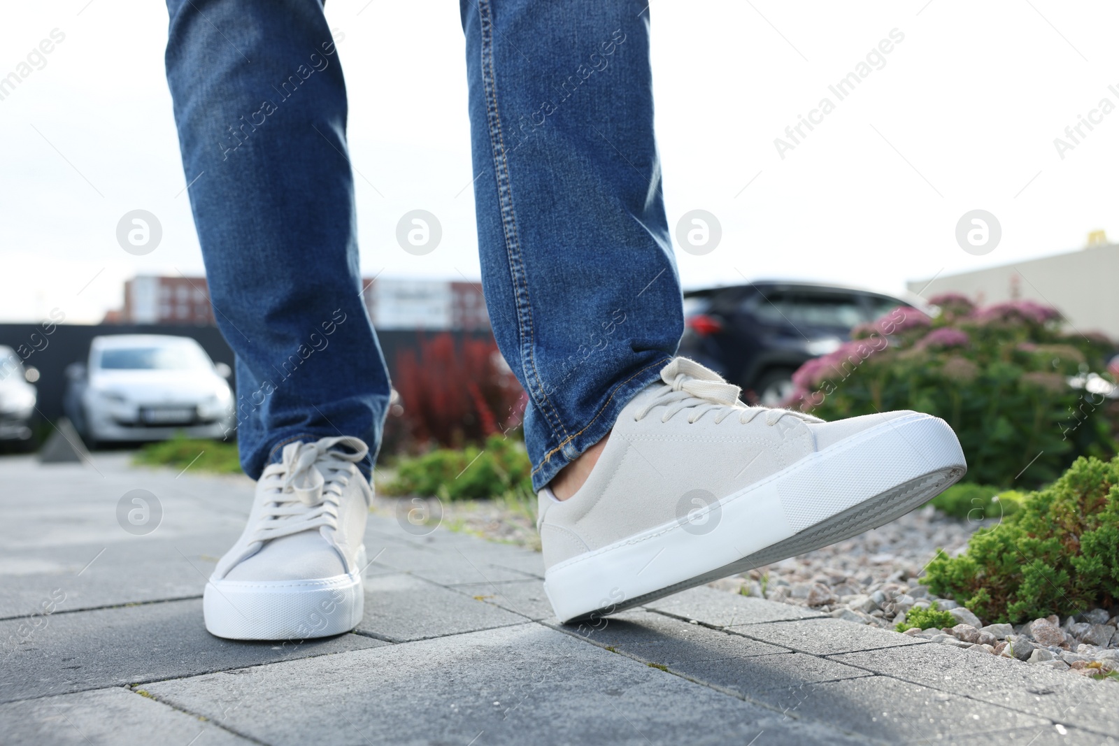 Photo of Man walking in stylish sneakers outdoors, closeup