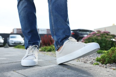 Man walking in stylish sneakers outdoors, closeup