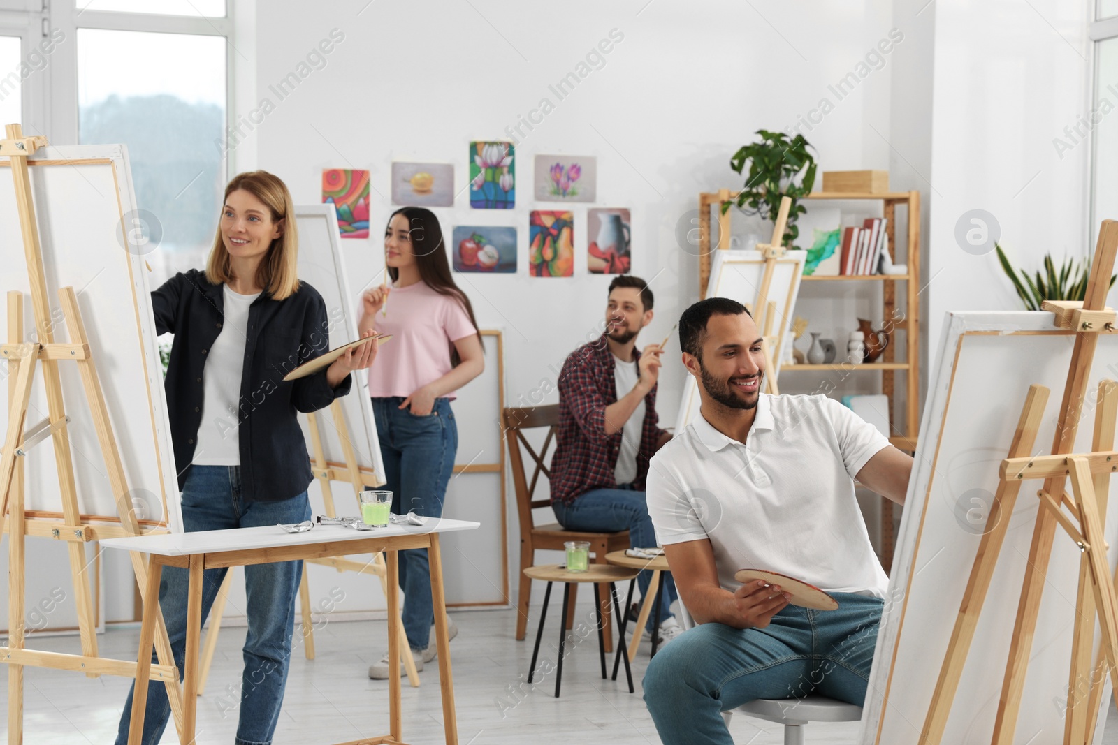 Photo of Group of students attending painting class in studio. Creative hobby