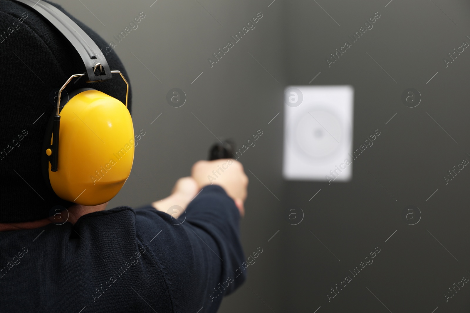 Photo of Man aiming at shooting target indoors, closeup