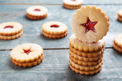 Traditional Christmas Linzer cookies with sweet jam on wooden background