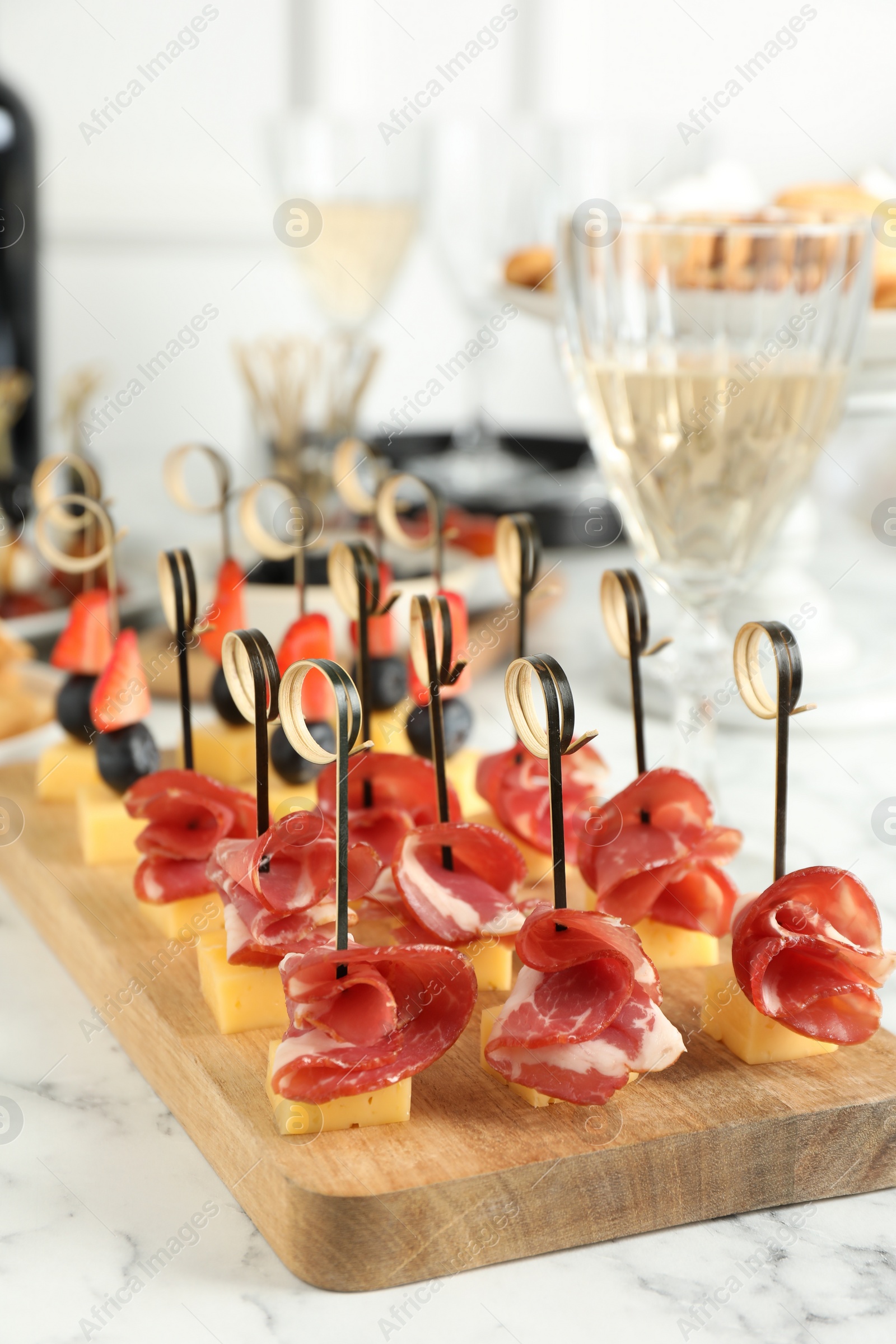 Photo of Different tasty canapes on white marble table, closeup