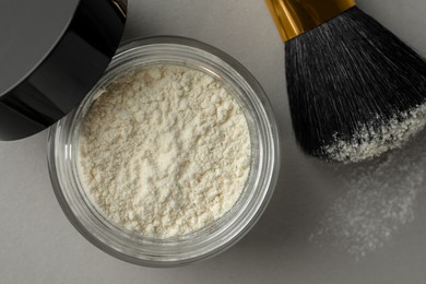 Photo of Rice loose face powder and makeup brush on light grey background, flat lay