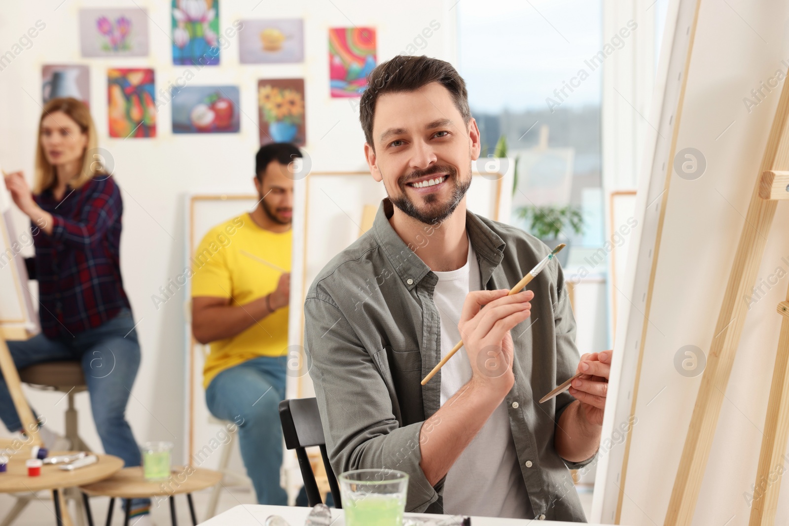 Photo of Group of students attending painting class in studio. Creative hobby