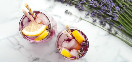 Image of Fresh delicious lemonade with lavender on white marble table, top view