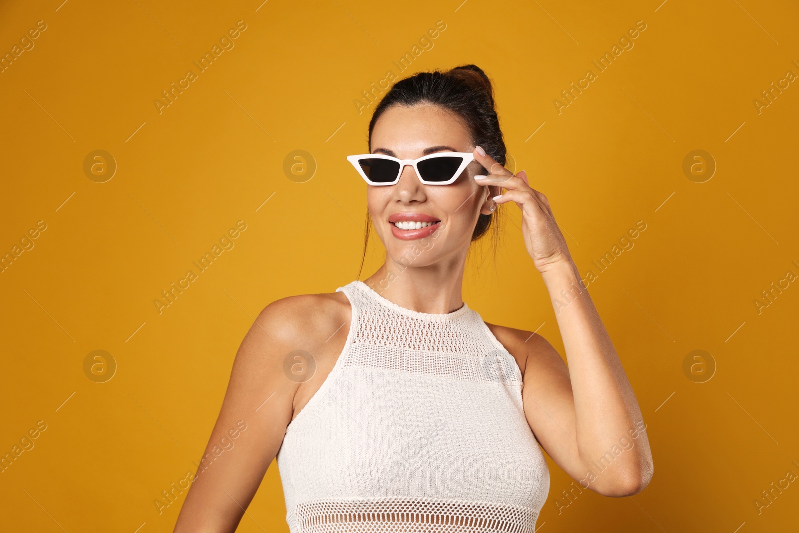 Photo of Beautiful woman in sunglasses on yellow background