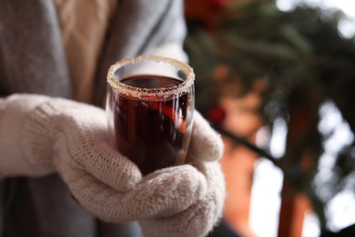 Photo of Woman with tasty mulled wine outdoors, closeup