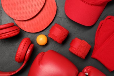 Photo of Different sports equipment on black table, flat lay