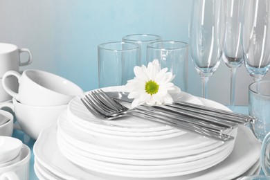 Photo of Set of clean dishes, glasses and cutlery on table, closeup