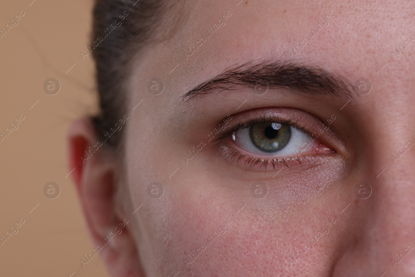 Photo of Closeup view of woman with beautiful hazel eyes on beige background