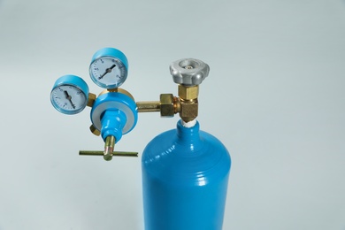 Oxygen tank on light grey background, closeup. Medical equipment