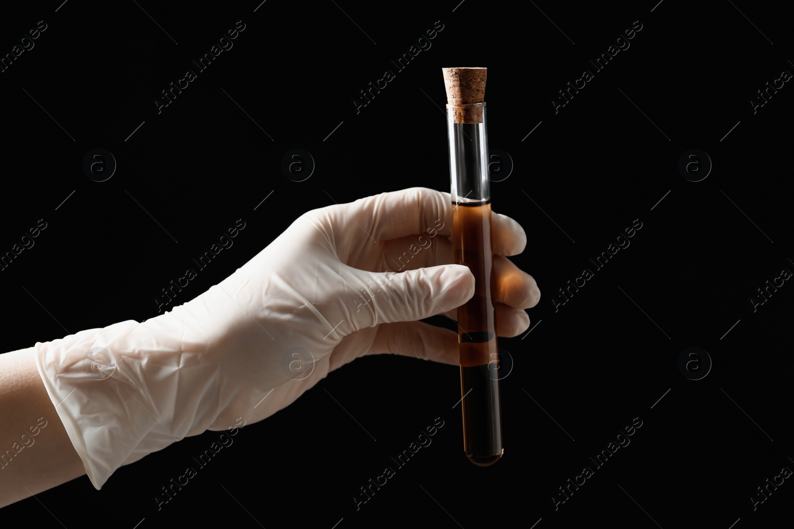 Photo of Scientist holding test tube with liquid on black background, closeup