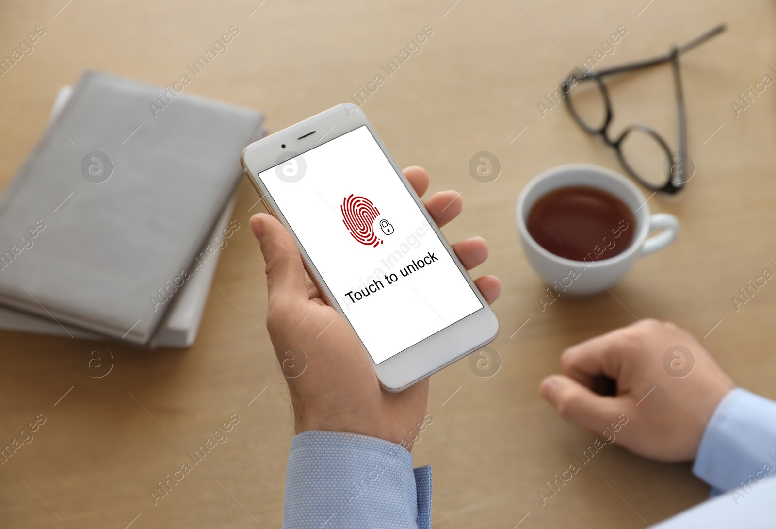 Image of Man holding smartphone with fingerprint sensor indoors, closeup. Digital identity