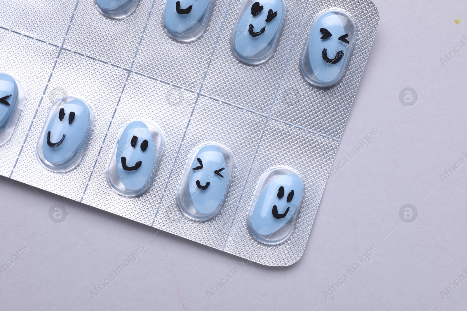 Photo of Antidepressants with different emoticons on grey background, top view
